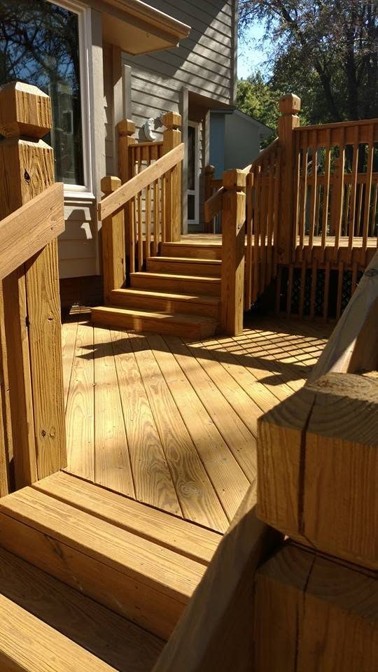 Wooden deck with stairs, railings, and gate leading to house entrance