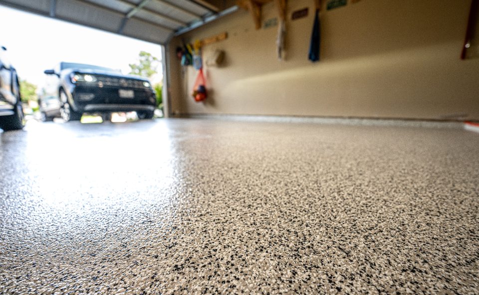 Polished epoxy garage floor with vehicle visible in background
