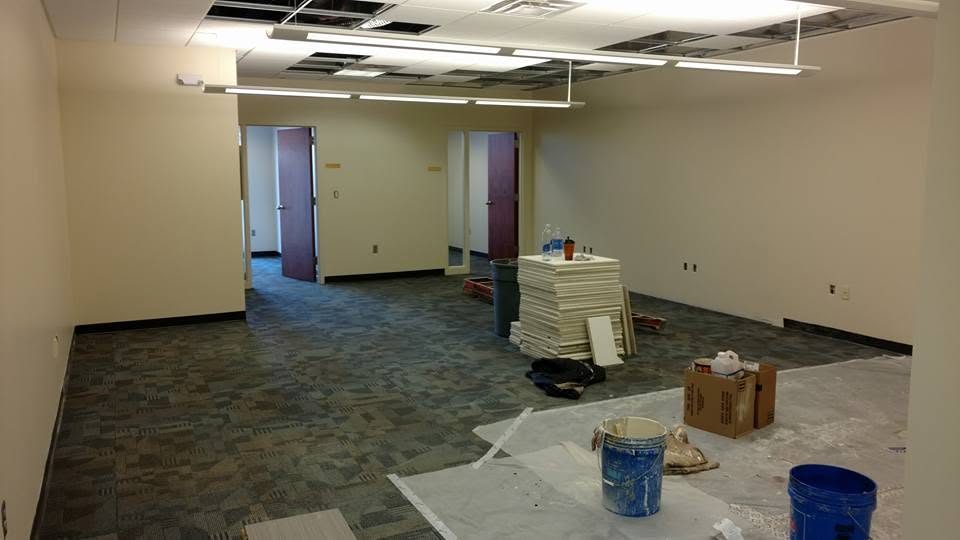 Commercial office space under renovation with exposed flooring and construction materials