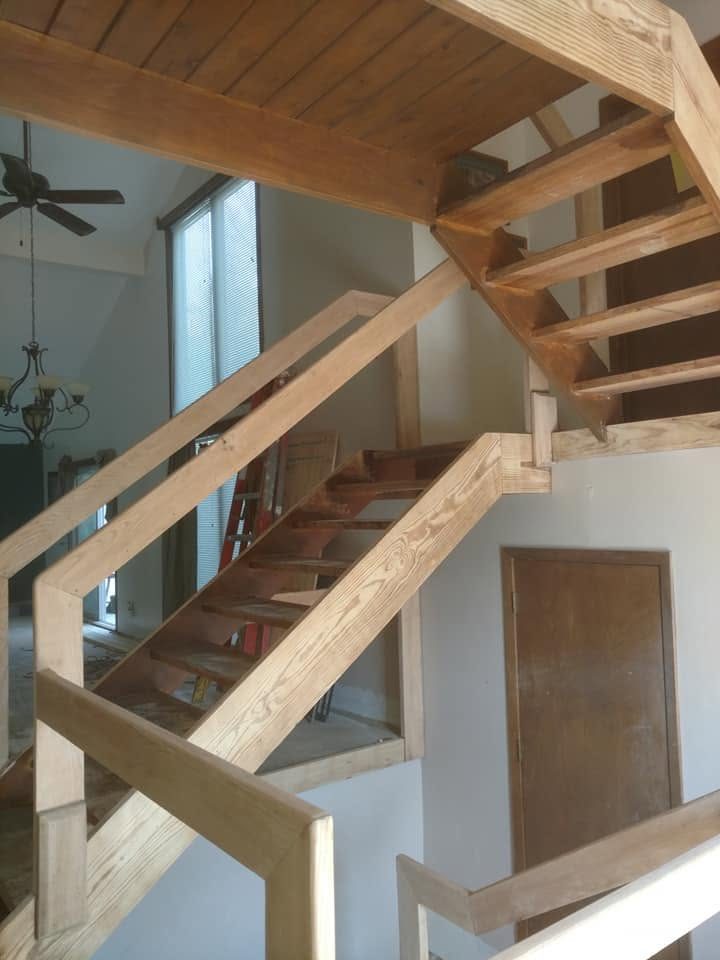 Modern wooden spiral staircase with glass railing in bright residential interior