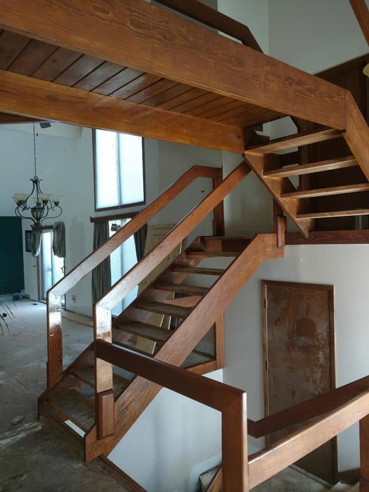 Modern wooden staircase with metal railings in multi-level home interior